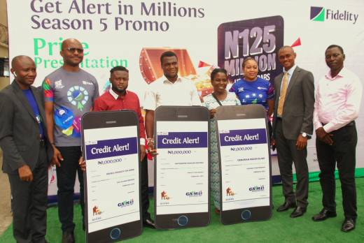 L- R: Head, Savings and Sales, Ukpai Ibe; Divisional Head, Product Development, Osita Ede; (both of Fidelity Bank Plc); 1million naira winners - Ebuka Stanley Chijioke, Akpobome Favour Okpako and Deborah Ngozi Elias; Regional Bank Head -Agege-Ikorodu, Cynthia Erigbuem; Regional Bank Head -Festac, Paschal Nzeribe (both of Fidelity Bank Plc); and Monitoring and Enforcement Officer, National Lottery Regulatory Commission, Niyi Adeleke at the Fidelity Bank Get Alert in Millions Season 5 (GAIM 5) Savings Promo fourth monthly prize presentation event in Lagos on Thursday, 24 March 2022.